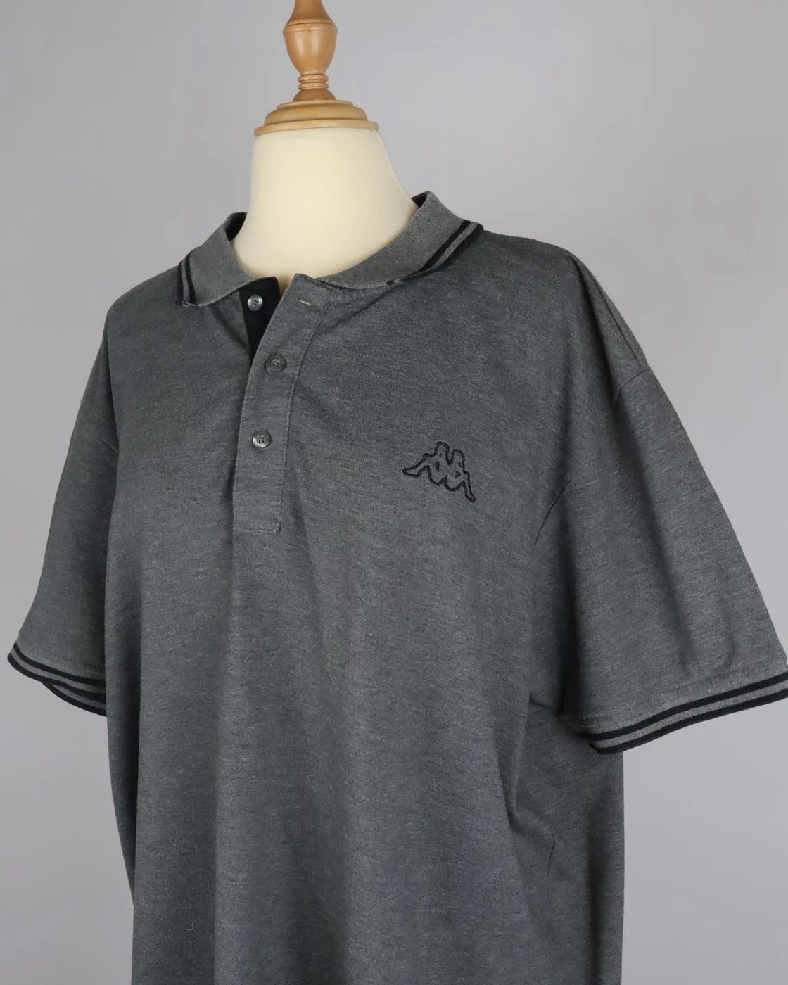 Photographie réelle d’un polo Kappa gris sur mannequin pour Thrift Addict